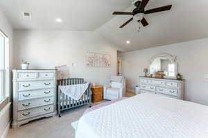 Carpeted bedroom featuring ceiling fan and lofted ceiling