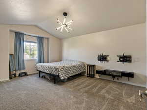 Carpeted master bedroom with vaulted ceiling