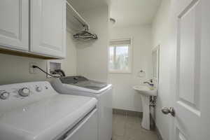 Laundry room featuring independent washer and dryer, cabinets and also a half bathroom.