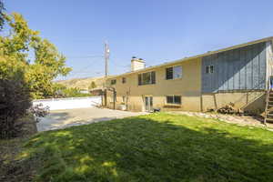 Rear view of house featuring a lawn and a sports court for you to enjoy.