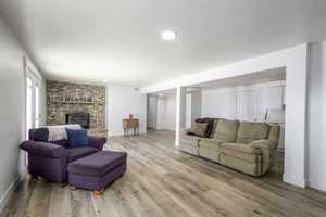 Living room with a brick fireplace, and light LVP flooring