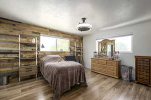 Main bedroom featuring an accent wood walls and great natural light.