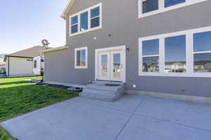 Rear view of property featuring a patio and a lawn