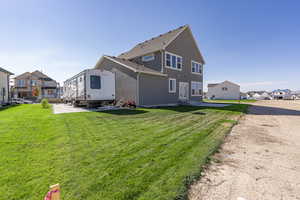 Rear view of house with a patio area and a lawn