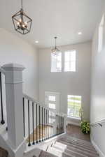 Stairway with carpet flooring and an inviting chandelier