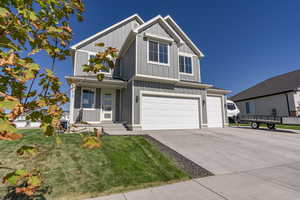 View of front of house featuring a front lawn and a garage