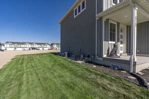 View of side of property featuring central AC and a lawn