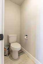 Bathroom with toilet and hardwood / wood-style flooring