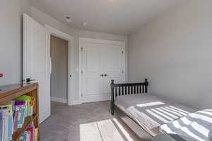 Bedroom with a closet and light colored carpet