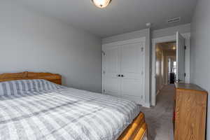 Bedroom with a closet and light colored carpet