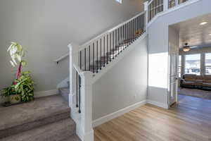 Stairs featuring hardwood / wood-style floors and ceiling fan