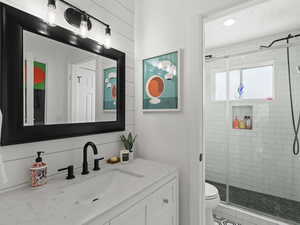 Bathroom featuring vanity, toilet, and an enclosed shower