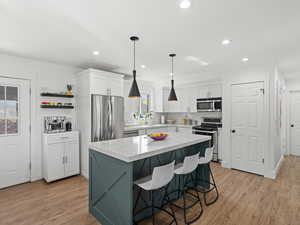 Kitchen with appliances with stainless steel finishes, white cabinetry, and plenty of natural light