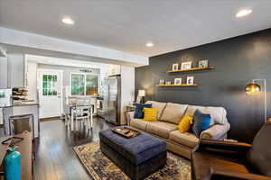 Living room with a textured ceiling and dark hardwood / wood-style floors