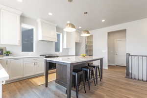 Kitchen with white cabinetry, a center island, and stainless steel range oven