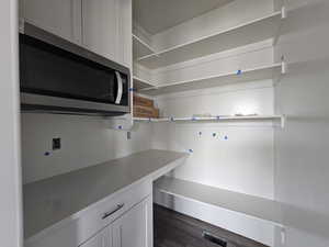 Kitchen with dark hardwood / wood-style floors and white cabinets