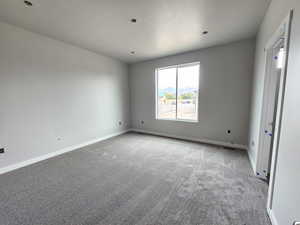 Carpeted spare room with a textured ceiling