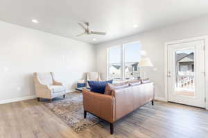 Living room with light hardwood / wood-style flooring and ceiling fan