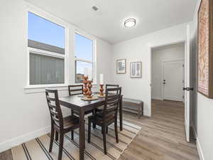 Dining area with light hardwood / wood-style flooring