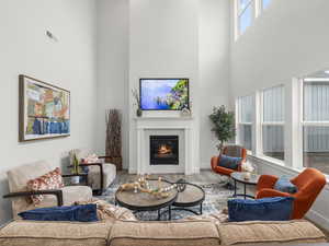 Great room featuring a towering ceiling and wood-type flooring