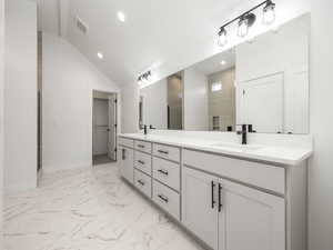 Master Bathroom featuring vanity, lofted ceiling, and a shower