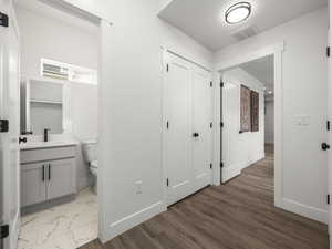 Corridor featuring a textured ceiling, sink, and light wood-type flooring