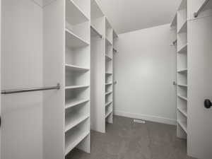 "Her" Spacious wak-in closet with light colored carpet