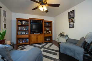 Living room with dark wood flooring and ceiling fan