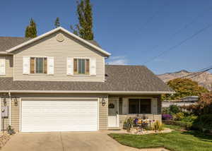 View of front of house with a mountain view, a front yard, and a garage