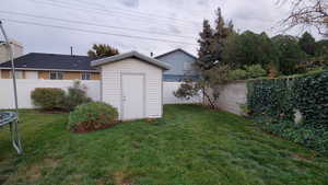 View of outdoor structure with a yard