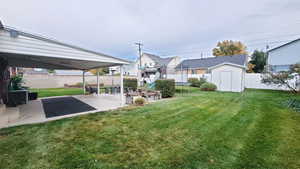 View of yard with a patio and a storage shed