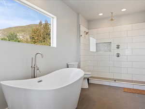 Master Bathroom featuring tile patterned floors, shower with separate bathtub, a mountain view, and toilet