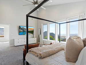 Master Bedroom with ceiling fan, a towering ceiling, and carpet floors