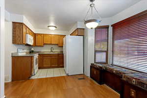 Kitchen featuring white appliances, light hardwood / wood-style floors, and sink