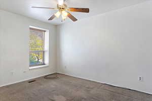 Carpeted empty room with ceiling fan