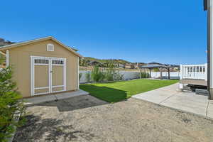 View of yard featuring a gazebo, a storage unit, and a patio area