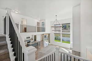 Staircase with hardwood / wood-style flooring, sink, and a chandelier