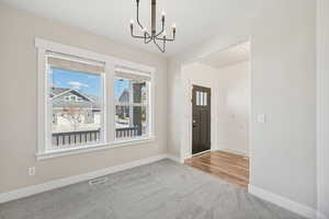 Entryway featuring carpet flooring and an inviting chandelier