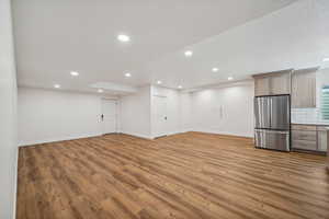 Basement featuring light hardwood / wood-style flooring and stainless steel fridge