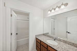 Bathroom with vanity, bathing tub / shower combination, and tile patterned floors