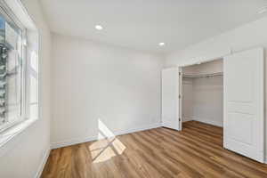 Unfurnished bedroom with a closet and hardwood / wood-style floors