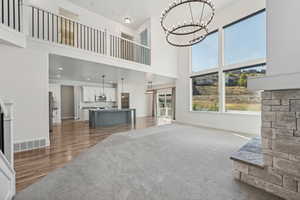 Living room featuring a high ceiling, a notable chandelier, and hardwood / wood-style flooring