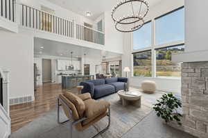 Living room featuring a towering ceiling, hardwood / wood-style floors, and a chandelier