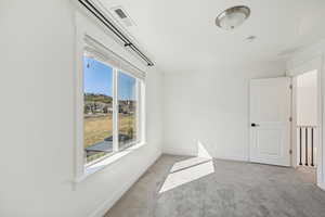 Carpeted empty room featuring a wealth of natural light