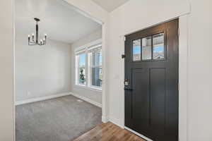 Entrance foyer with a notable chandelier and hardwood / wood-style floors