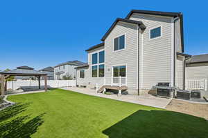 Rear view of house with a yard, a gazebo, and a patio area