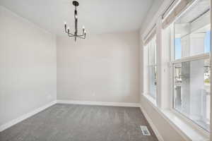 Empty room with a notable chandelier and carpet