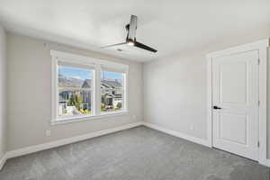 Unfurnished room with ceiling fan and carpet flooring