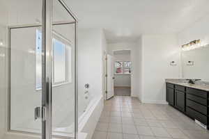 Bathroom featuring vanity, plus walk in shower, and plenty of natural light