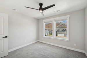 Unfurnished room featuring ceiling fan and carpet flooring